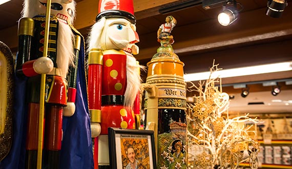 A selection of German nutcrackers and steins in a room with rustic wooden pillars