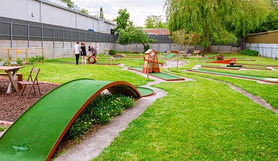 A mini golf course surrounded by lush green grass