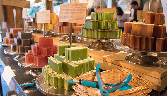 A variety of colourful soaps displayed on a wooden bench